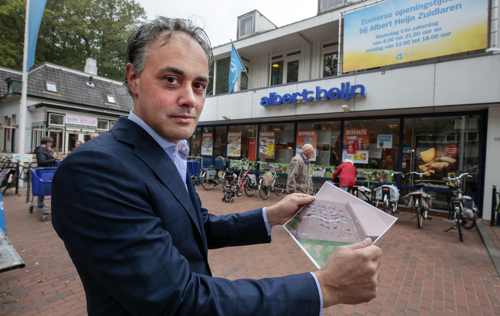 Hans Hendrikse in 2014 met een tekening van de tijdelijke winkel. Foto: Jan Willem van Vliet