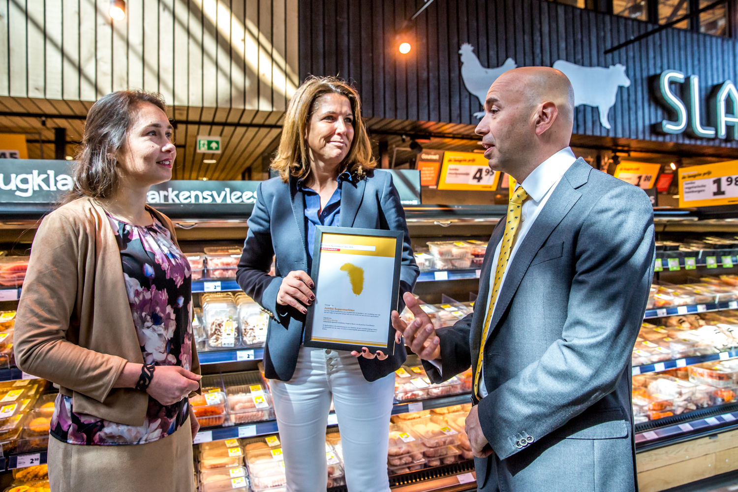 Directeur Commercie Ed van de Weerd en CCO Colette Cloosterman-van Eerd nemen de Agrofoodpluim van gedeputeerde Anne-Marie Spierings (links) van de Provincie Noord-Brabant in ontvangst bij Foodmarkt Veghel.