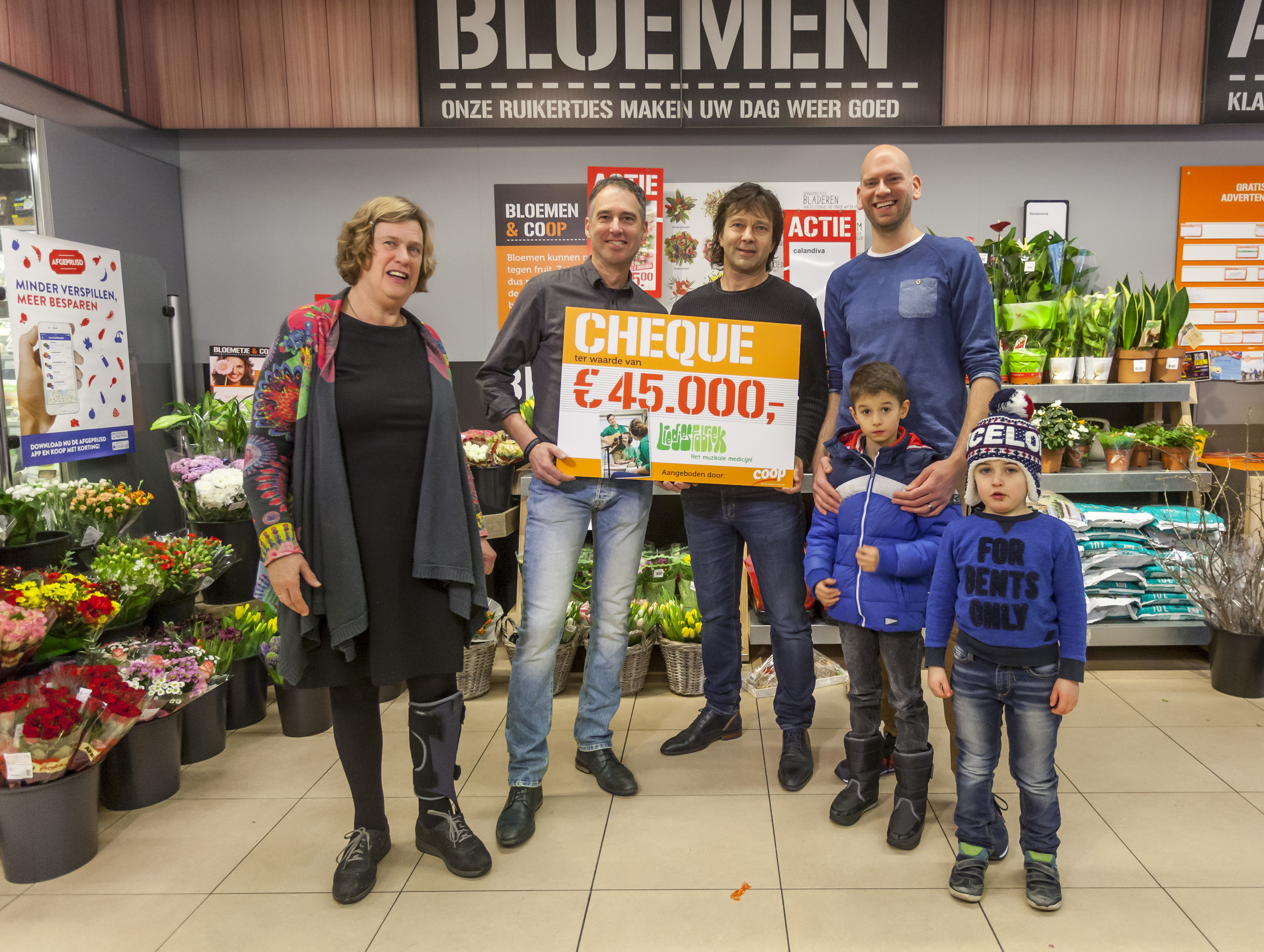 Oprichters Patrick Spierts en Leon Winters (midden) van de Liedjesfabriek nemen de cheque in ontvangst van Coop-ondernemer Bart te Plate (rechts) en Coöperatieraadslid Marlies van Hulsentop.