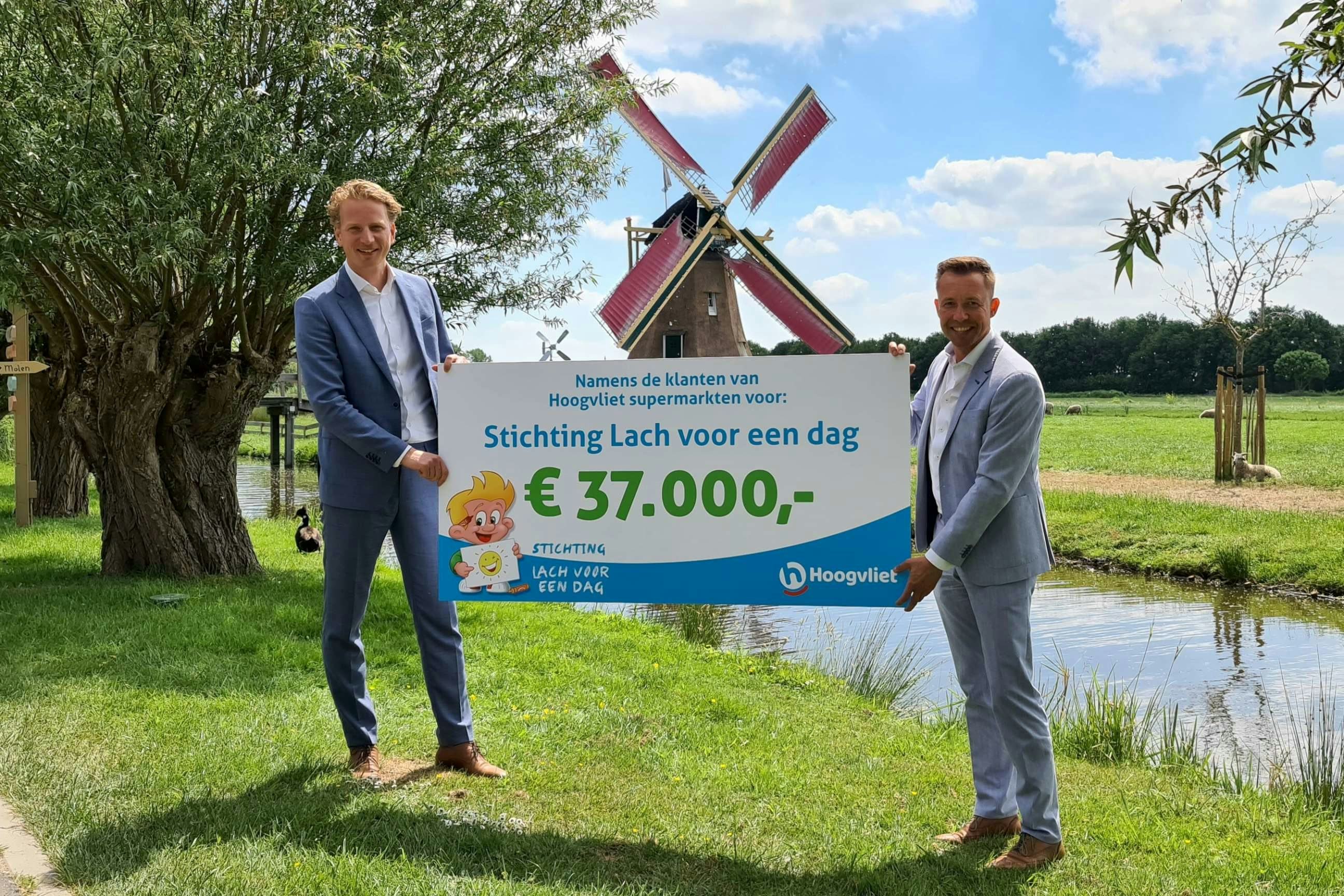 Adjunct-directeur Sebastiaan van Duijn van Hoogvliet (links) overhandigt de cheque aan Michael van Hoorne van Stichting Lach voor een Dag. Foto: Hoogvliet