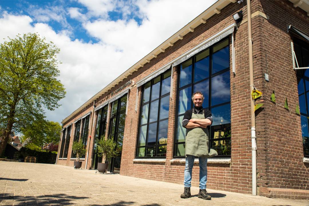 Eigenaar Thijs van der Meer voor het schoolgebouwtje dat nu versmarkt De 3 Ambachten is.