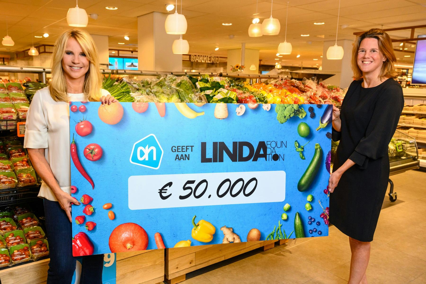Marit van Egmond (rechts) reikt de cheque uit aan Linda de Mol. 