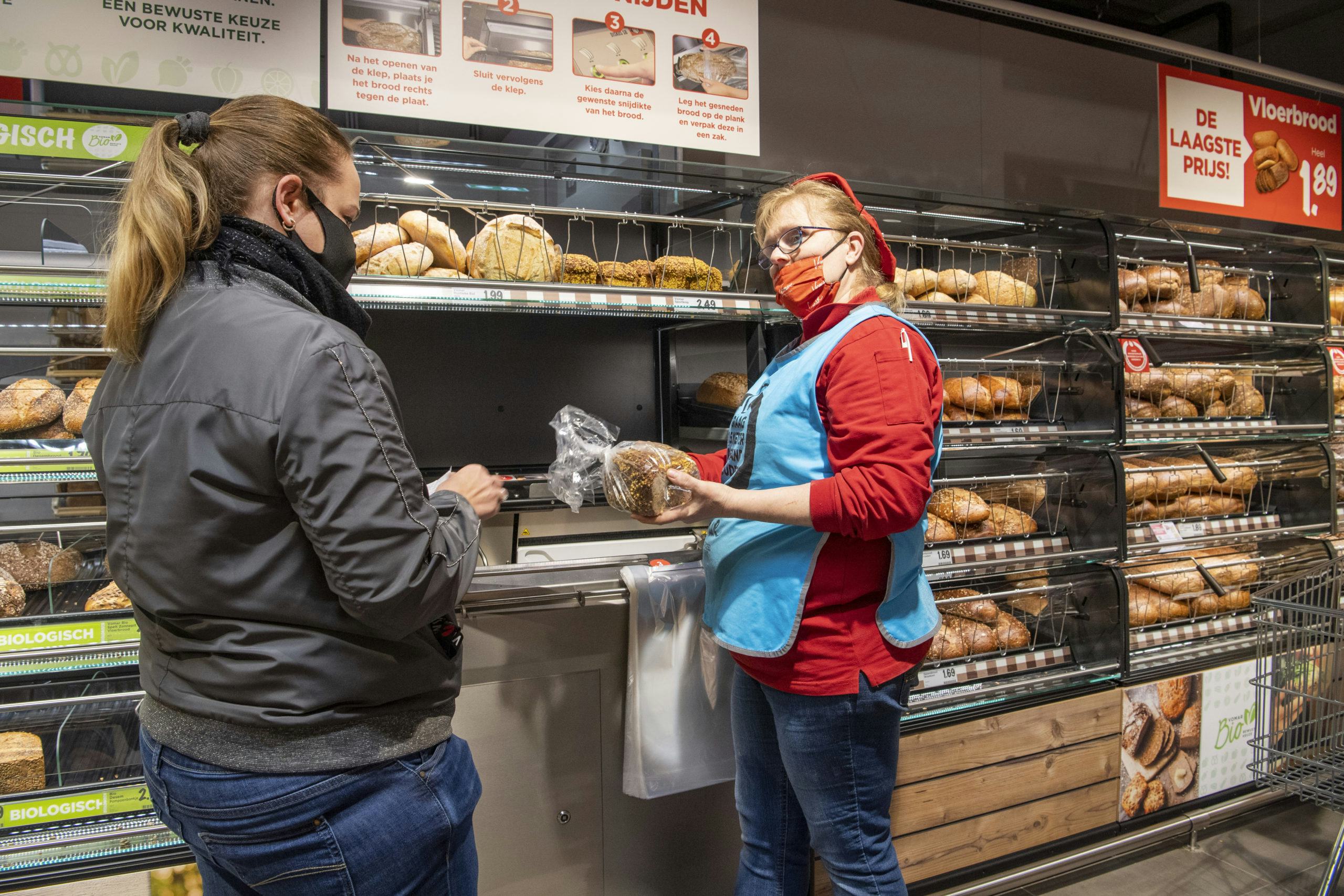 Een medewerker legt uit hoe de broodsnijmachine werkt. Foto: Cor Salverius