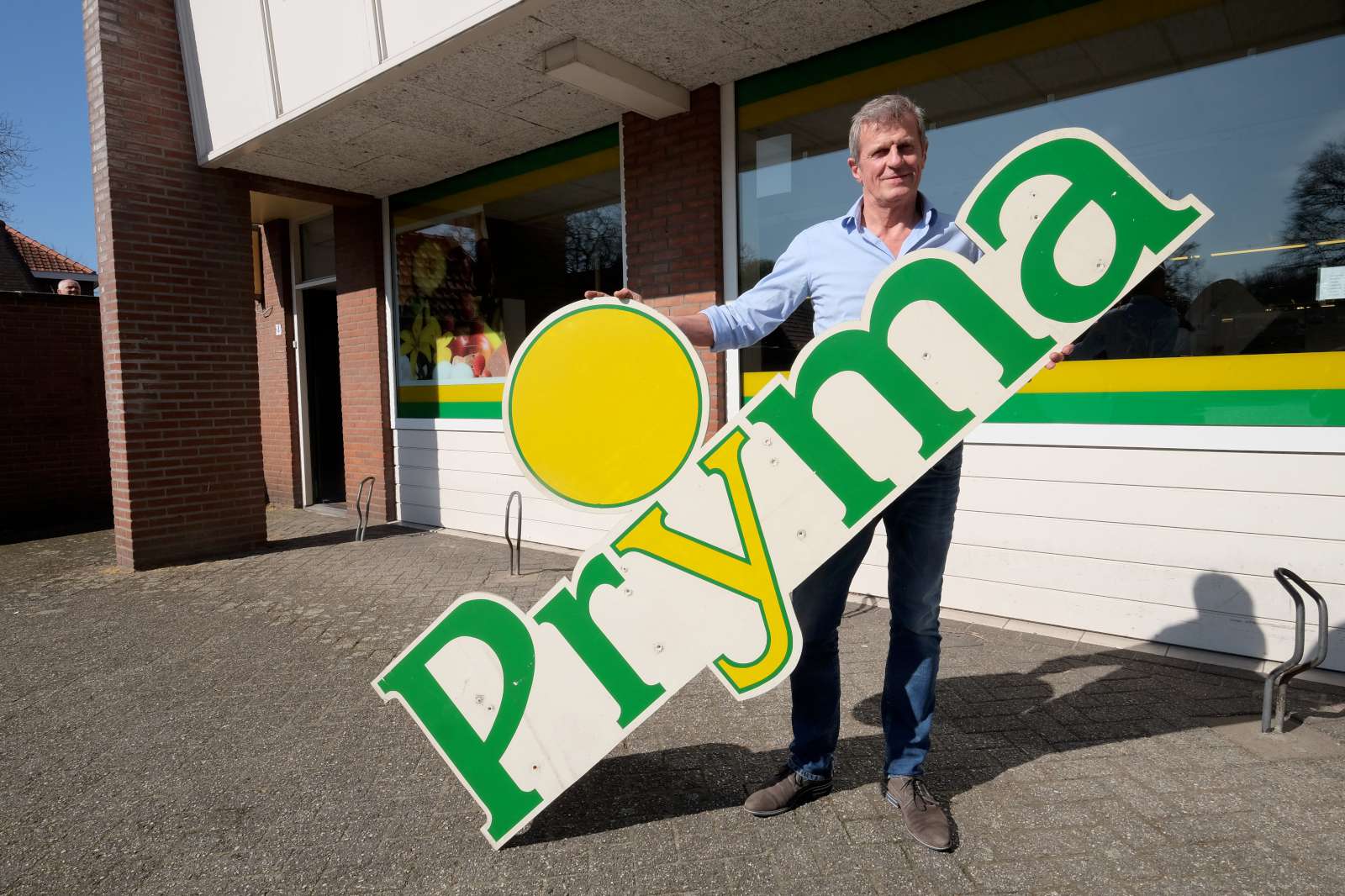 Jean-Louis van Eldonk met het bord dat al van de gevel verdween. Foto: Distrifood. 