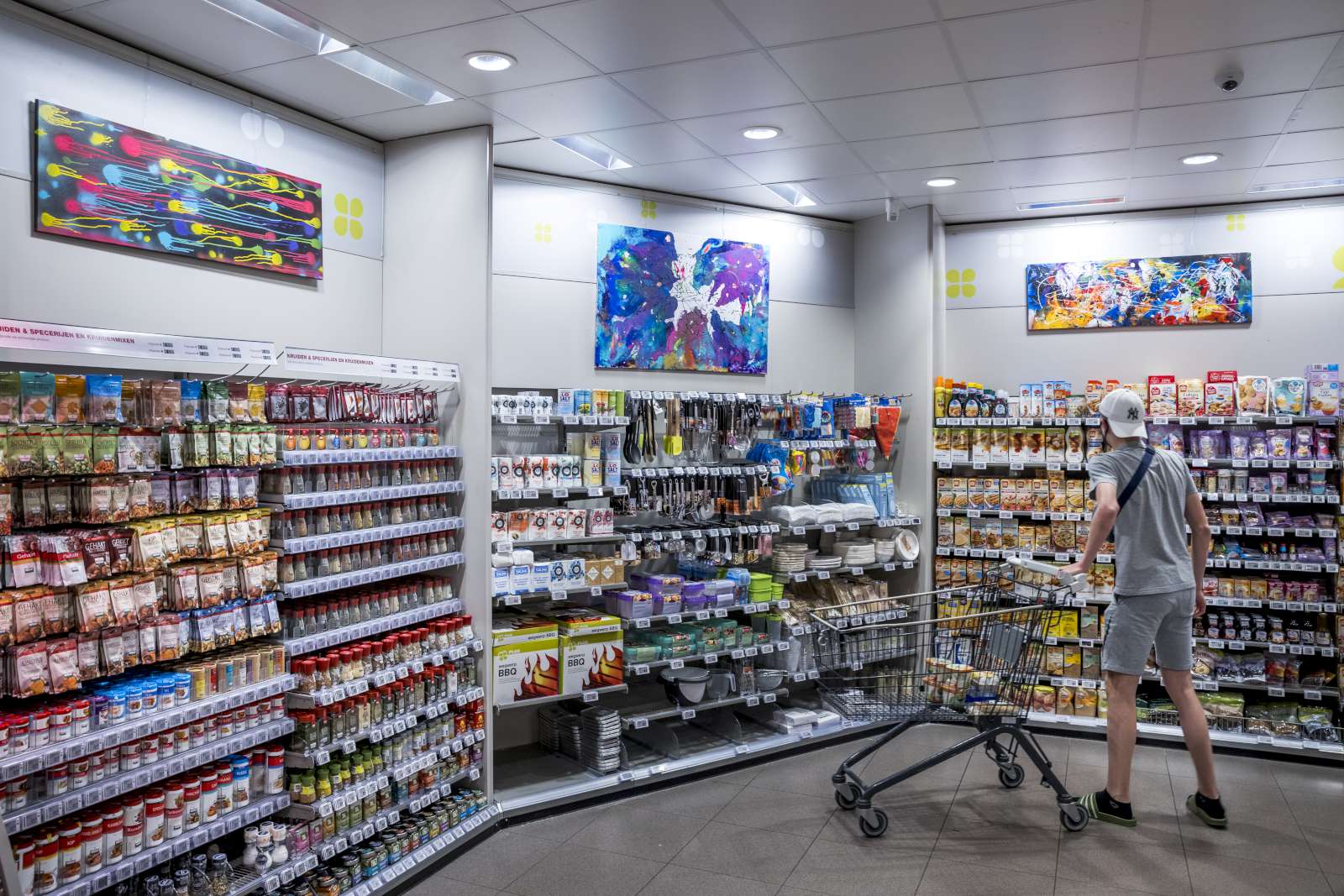 Een klant bekijkt de schilderijen van Shilo Lousberg in Plus Boudy Postma. Foto: Marcel van Hoorn