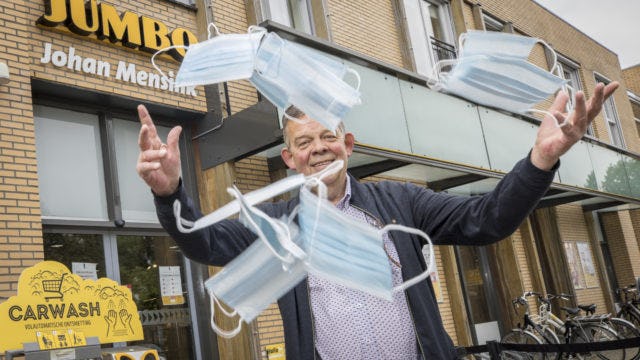 Jumbo-ondernemer Johan Mensink in Bathmen gooit symbolisch mondmaskers in de lucht als de mondkapjesplicht in juni 2021 voor het eerst vervalt. Archieffoto: Koos Groenewold