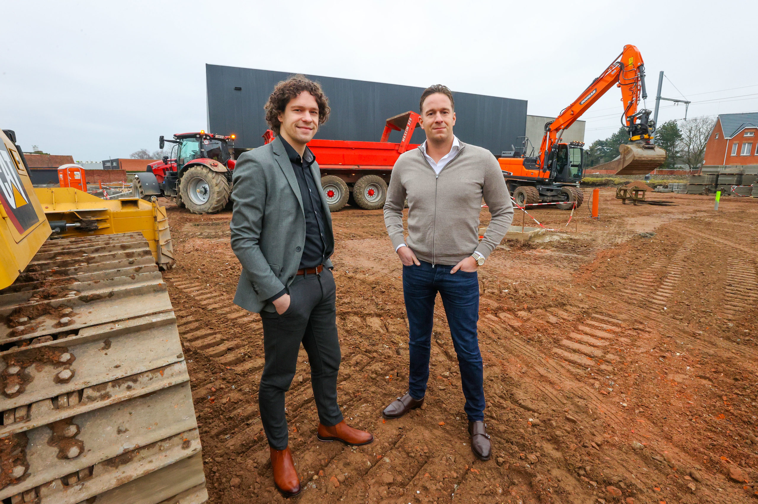Links Jason en rechts Martijn Vis. Achter hen de nieuwe Jumbo in aanbouw.
