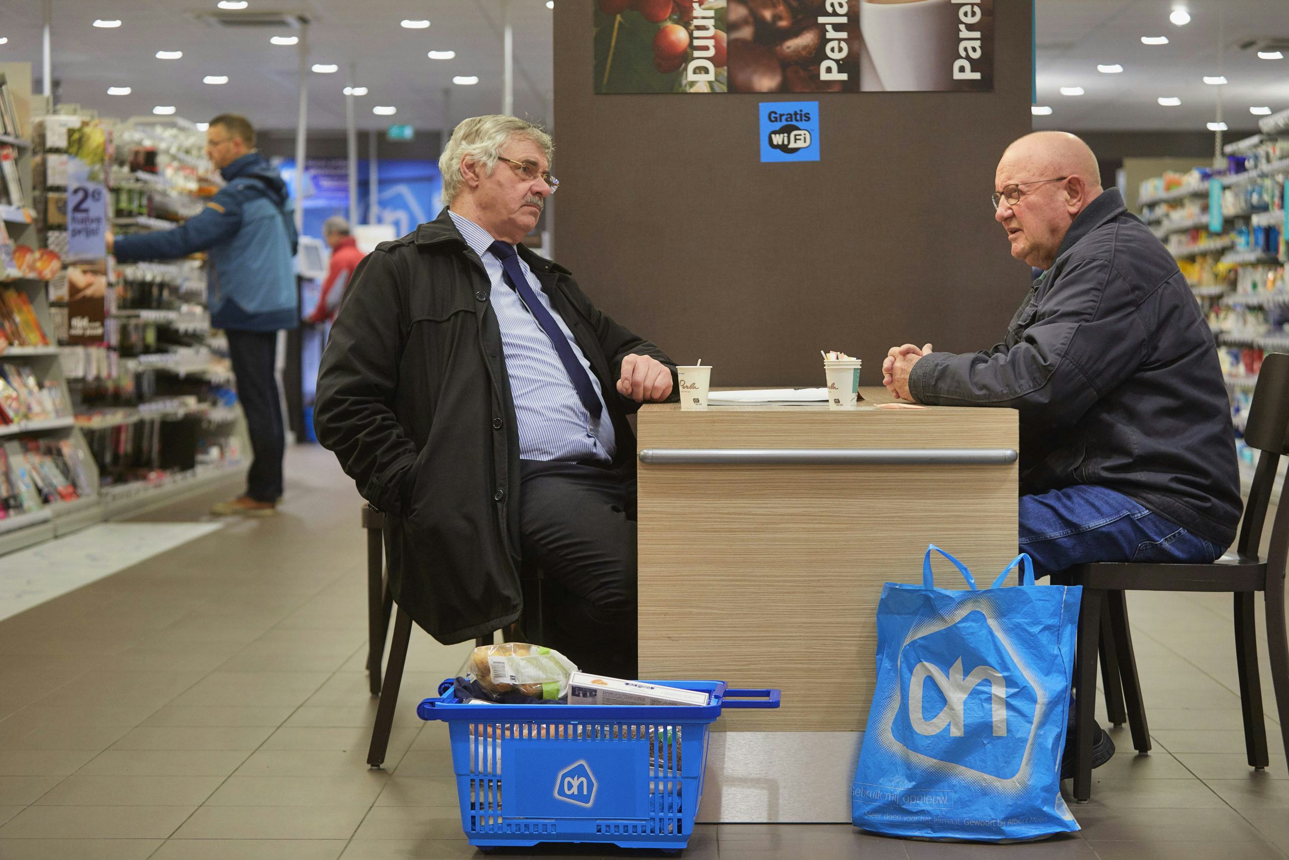 Mannen drinken koffie in een Albert Heijn-filiaal. Foto: ANP