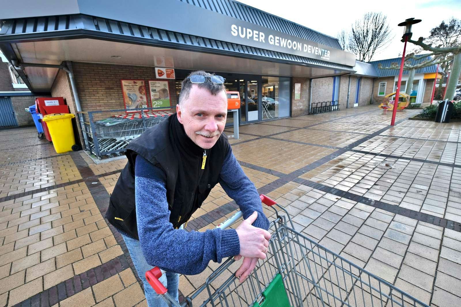 Willem van de Vlag voor zijn supermarkt. 'Doe maar gewoon', gaat voor hem niet op.