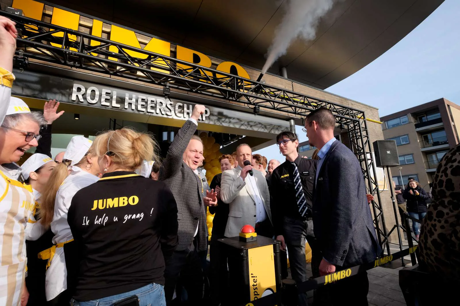 Jumbo-cfo Ton Van Veen (vuist) en Roel Heerschap (met microfoon) openen de winkel. Foto: Distrifood.
