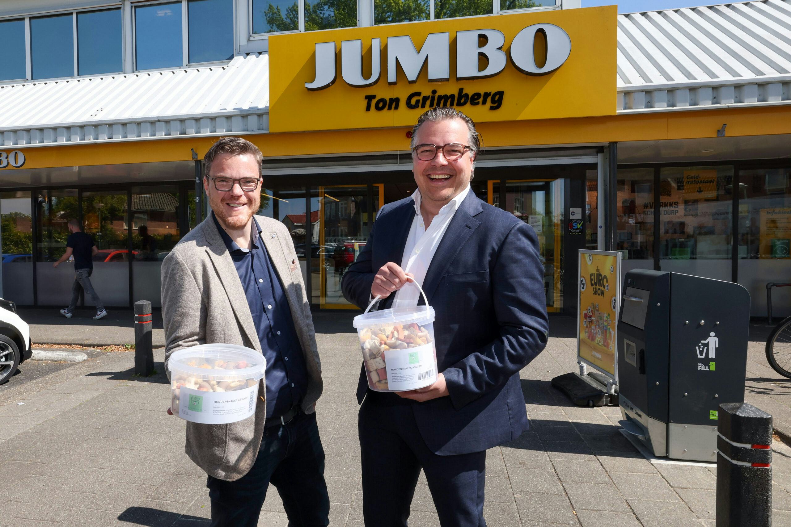 Rob Veltink en Roland Grimberg voor de winkel van de laatste met de emmers verbruiksartikelen waarmee ze willen scoren. Foto Bert Jansen.