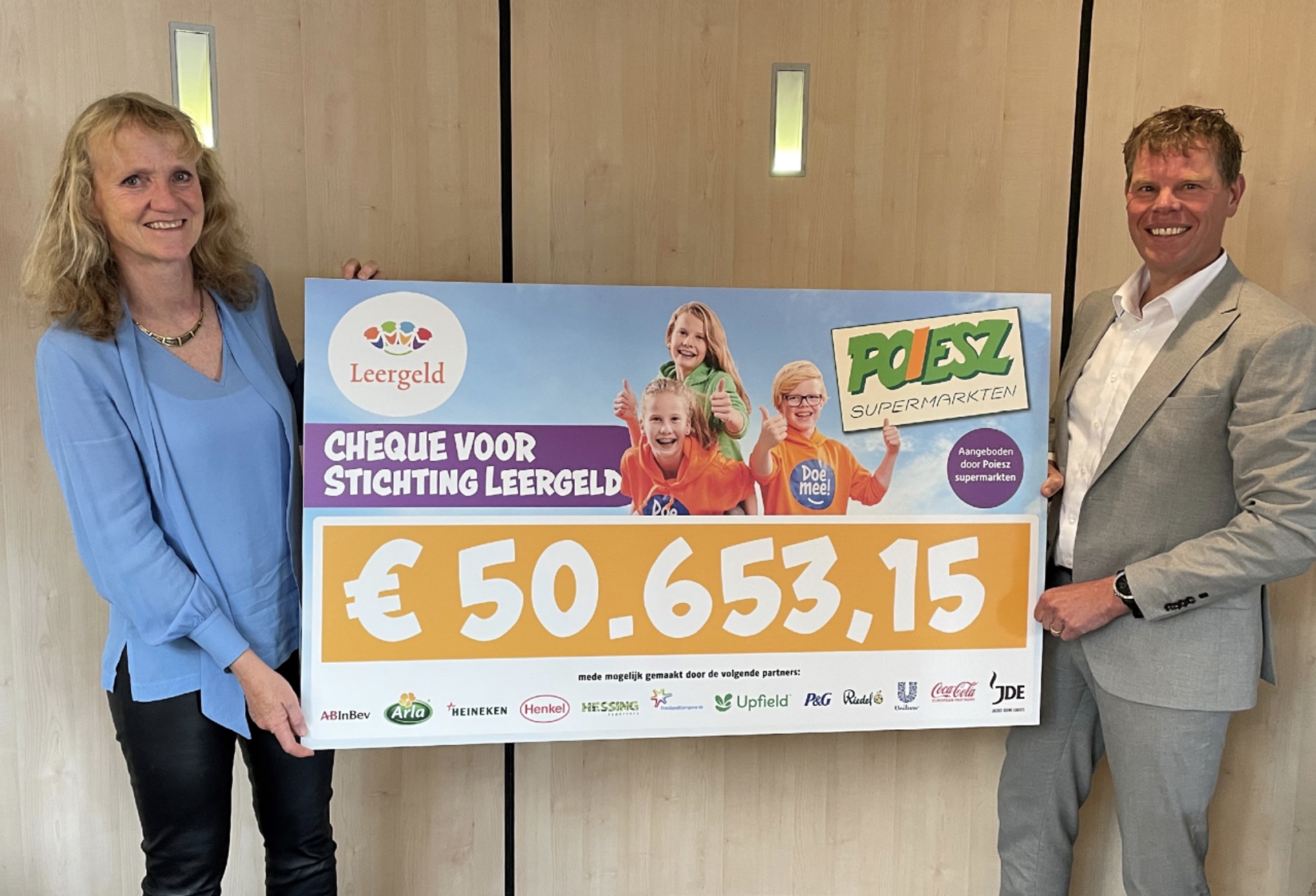 Richard Poiesz (rechts) rijkt een cheque uit aan de Stichting Leergeld. Foto: Poiesz
