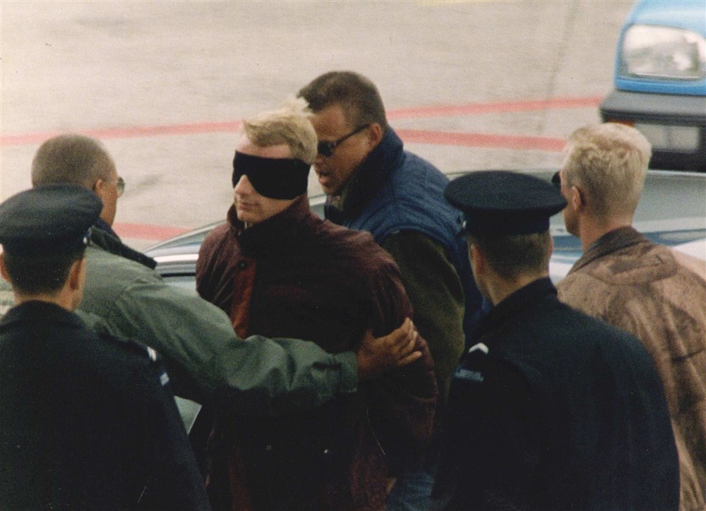 De dader van de fatale overval op AH Oosterbeek bij zijn terugkeer in Nederland. Foto: ANP