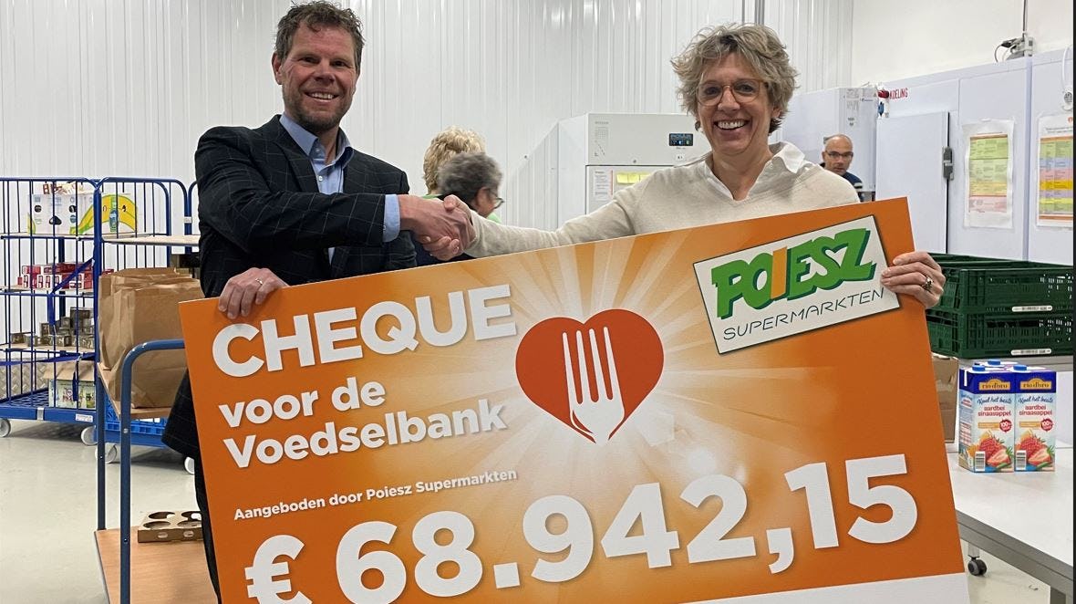 In de vestiging van de Voedselbank in Sneek overhandigt Richard Poiesz (commercieel manager Poiesz) de cheque uit aan Liliane van Heteren (Fondsenwerving Voedselbanken Nederland). Foto: Poiesz.