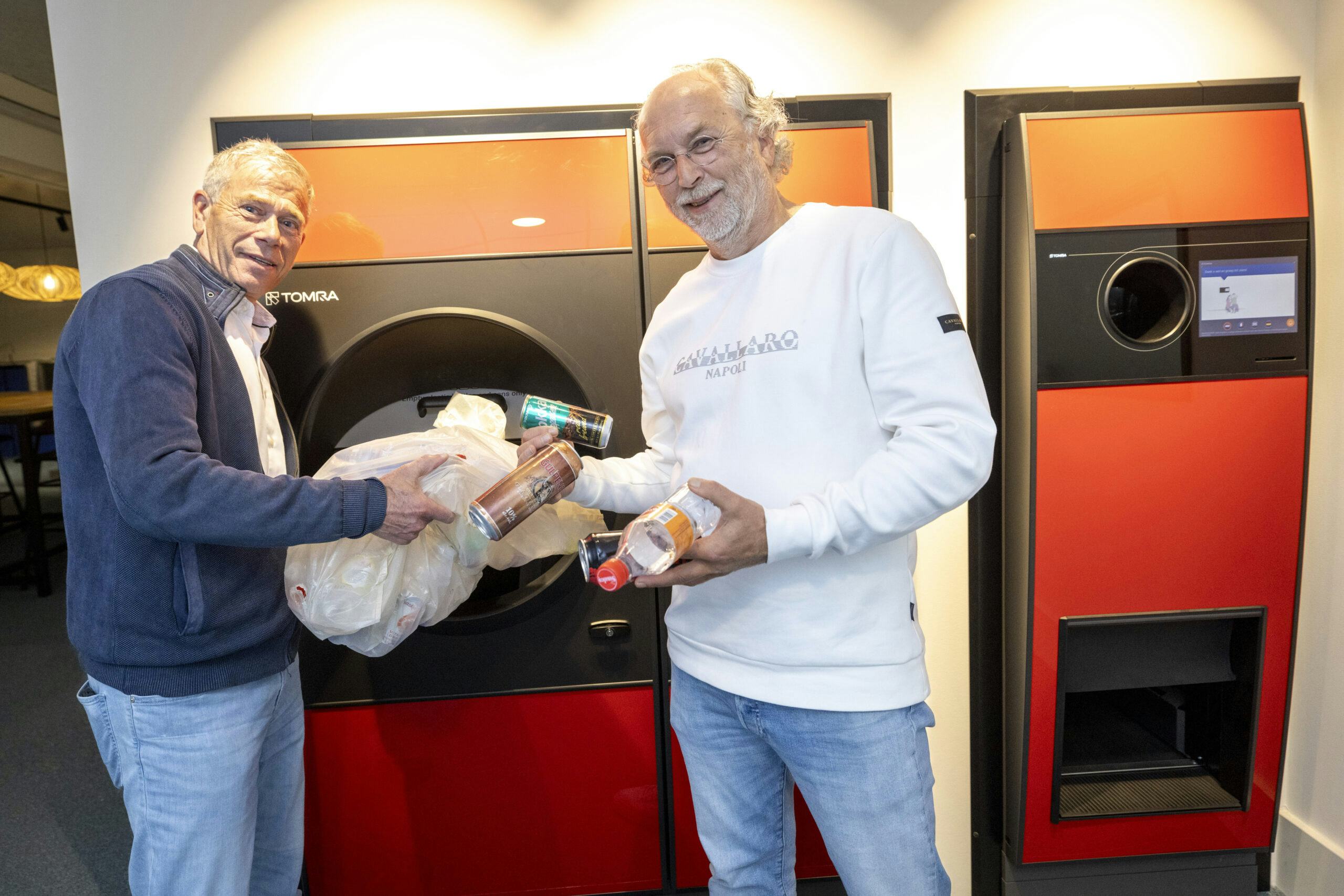 Mark Delwig René Hissink, van Tomra bij een nieuwe statiegeldautomaat waarin een hele zak flesjes en blikjes tegelijk kan. Foto: Koos Groenewold