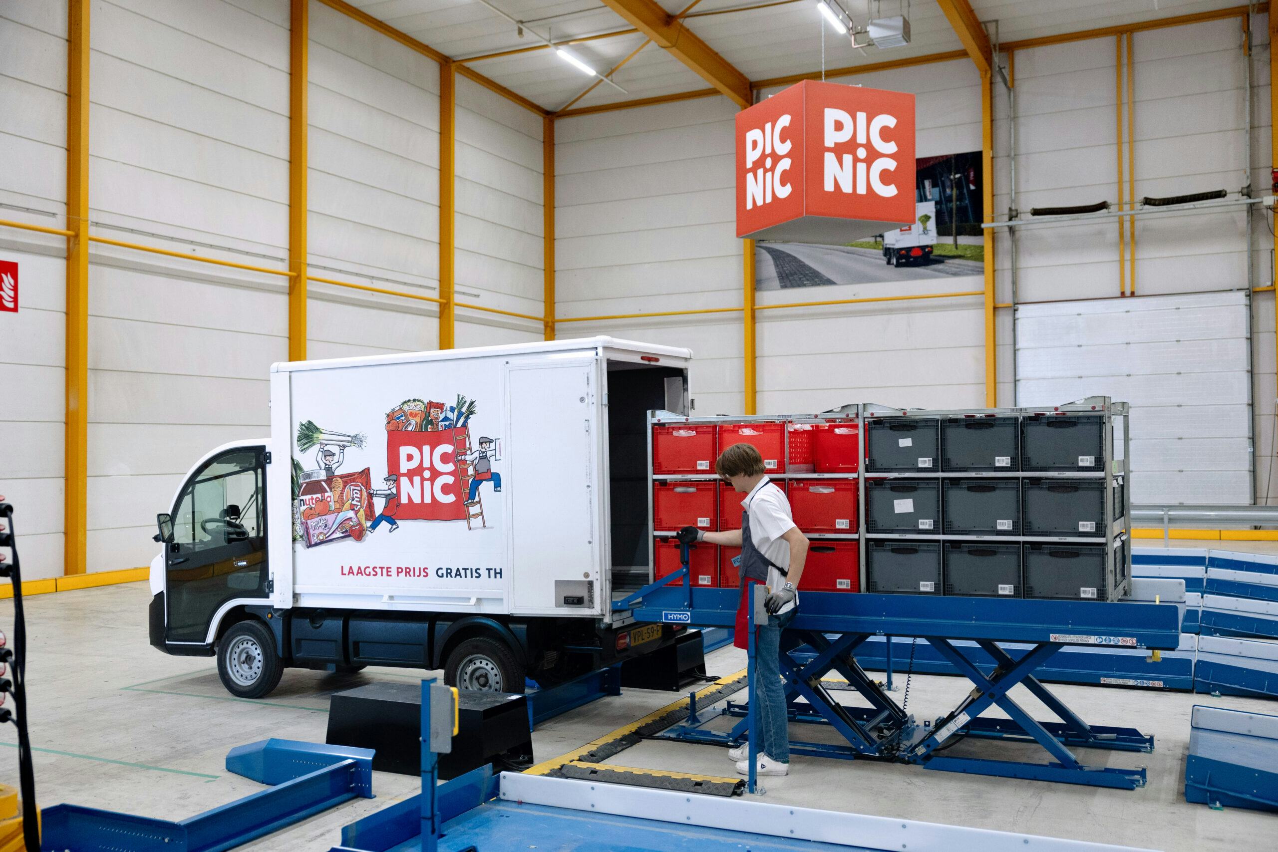 De wagentjes van Picnic worden ingeladen met een hefplatform. Foto: Herbert Wiggerman