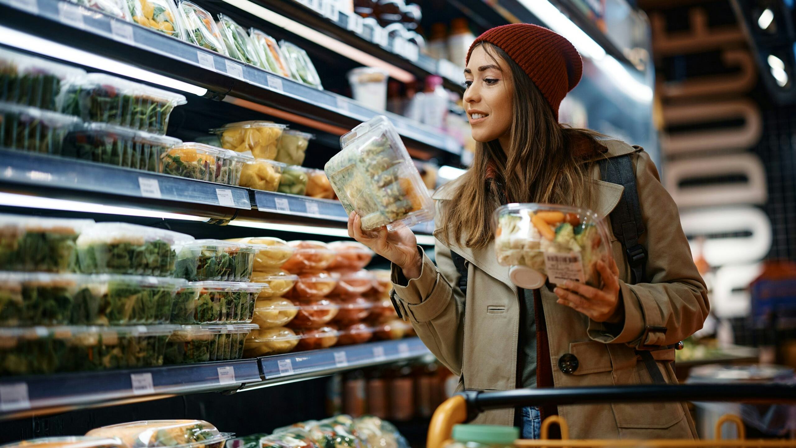 Een vrouw bekijkt de ingrediënten op de verpakking van een salade. Foto: Shutterstock