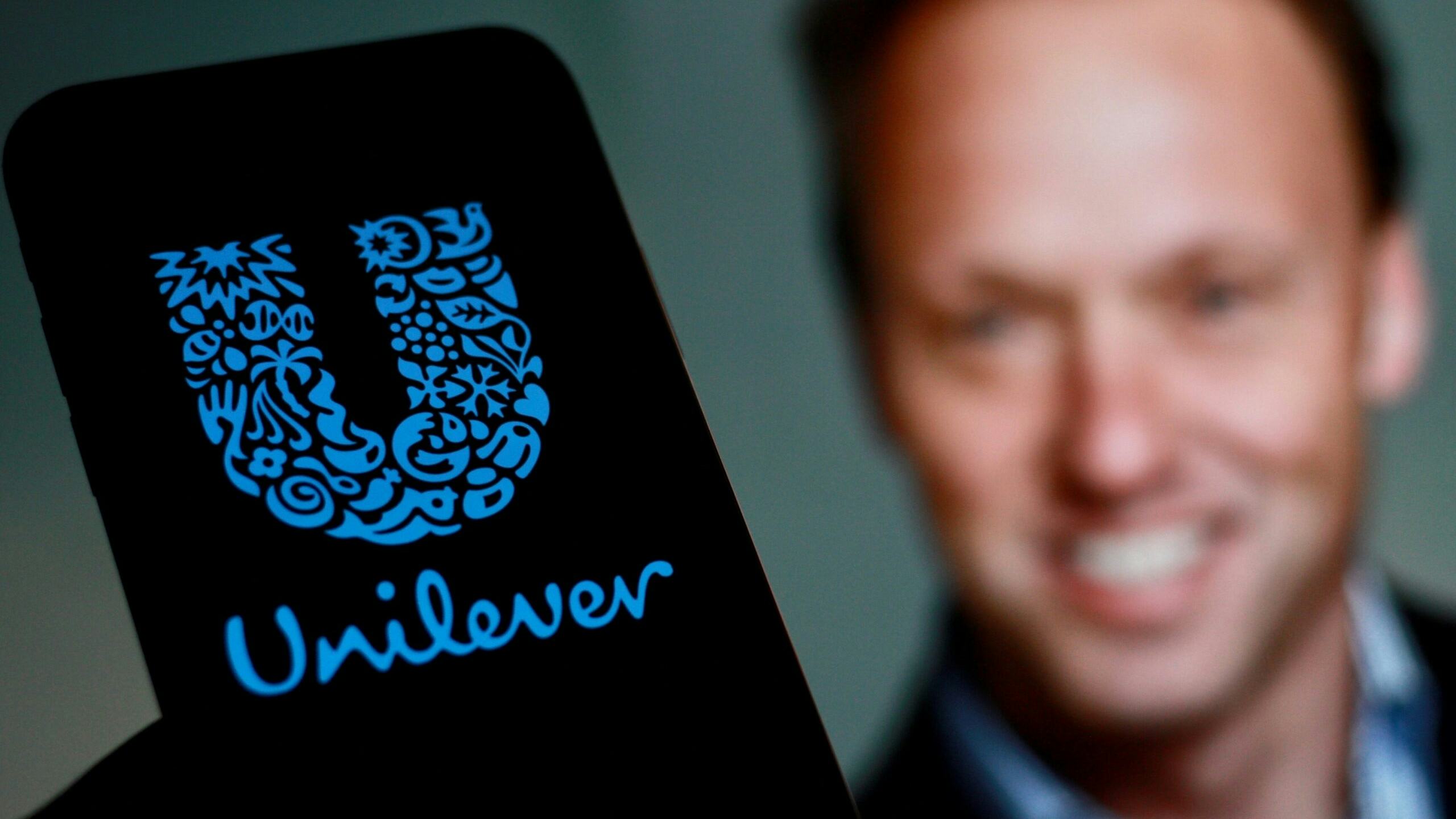 Unilever-topman Hein Schumacher toont een telefoon met Unilever-logo. Foto: Shutterstock