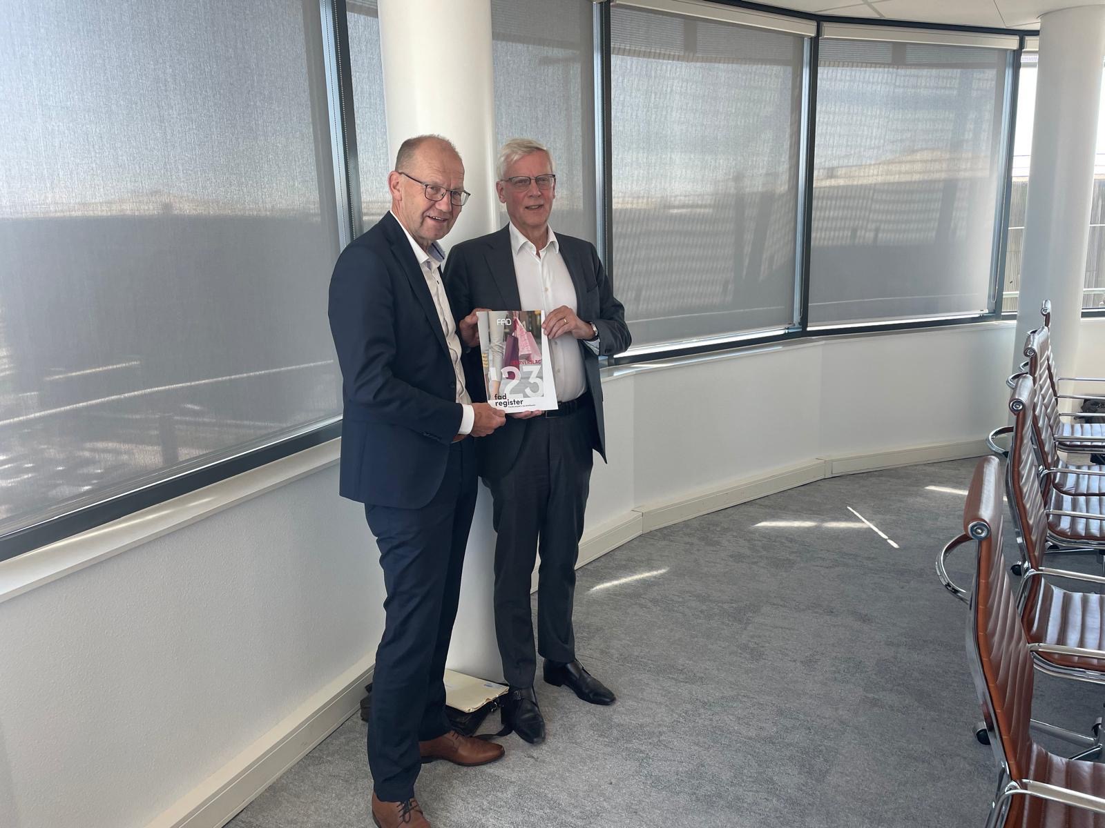 Joop Atsma overhandigt het jaarverslag van de stichting Fraude Aanpak Detailhandel aan Marnix van Rij. Foto: FAD