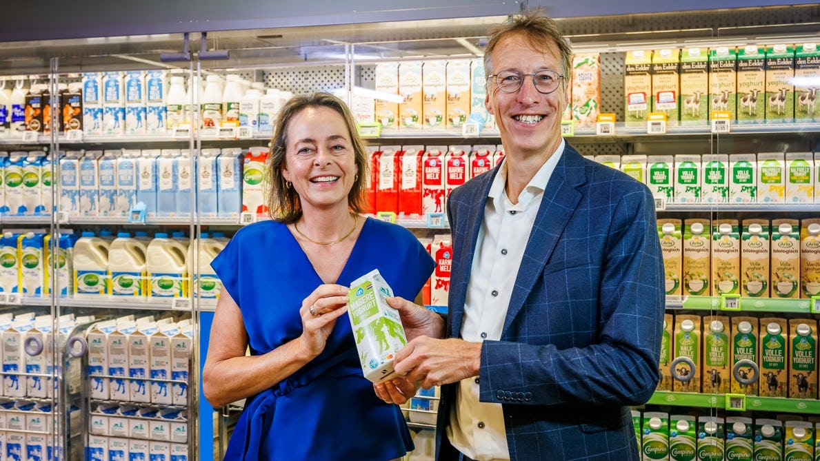 Anita Scholte op Reimer, directeur duurzaamheid en kwaliteit bij Albert Heijn overhandigt het eerste product met het nieuwe logo aan Toine Timmermans van de Stichting Samen Tegen Voedselverspilling. Foto: AH