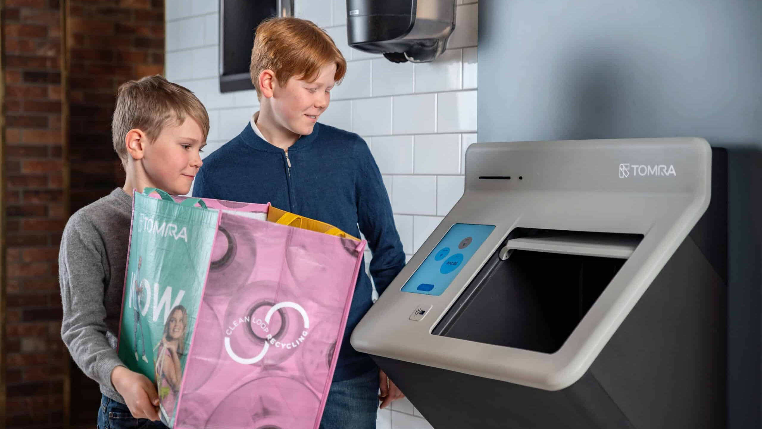 Kinderen leveren een tas met statiegeld in bij een Tomra R2. Foto: Tomra
