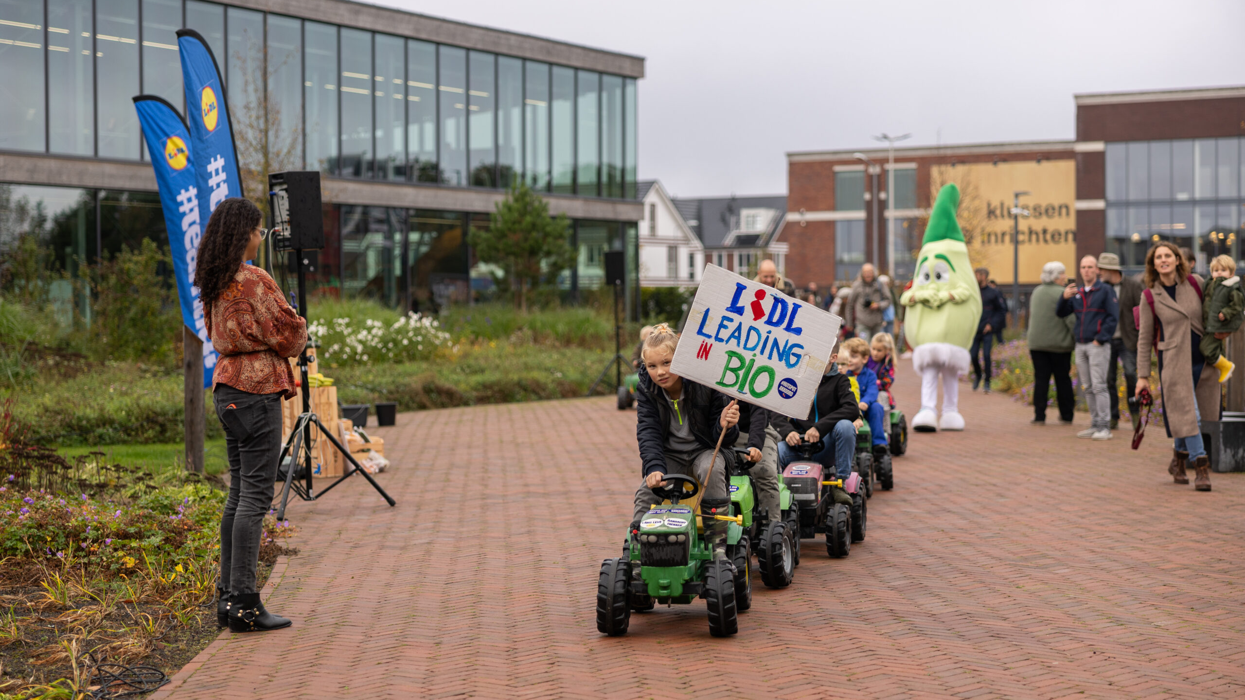 Kinderen op traptrekkers rijden het terrein van Lidl in Huizen op. Foto: Henk van der Giesen