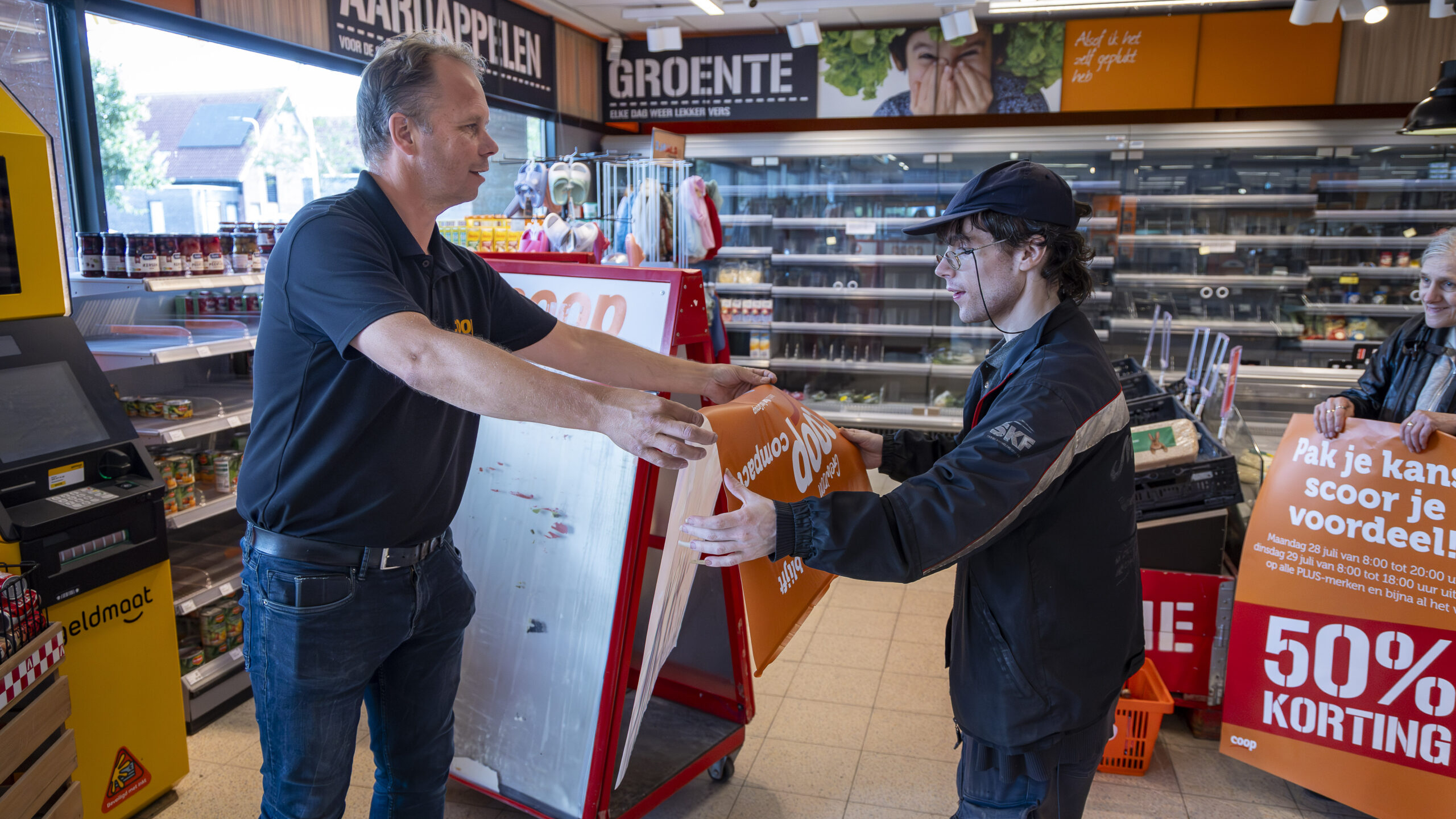Ondernemer Hobma met een van de laatste klanten bij de sluiting van de Coop. Foto: Koos Groenewold