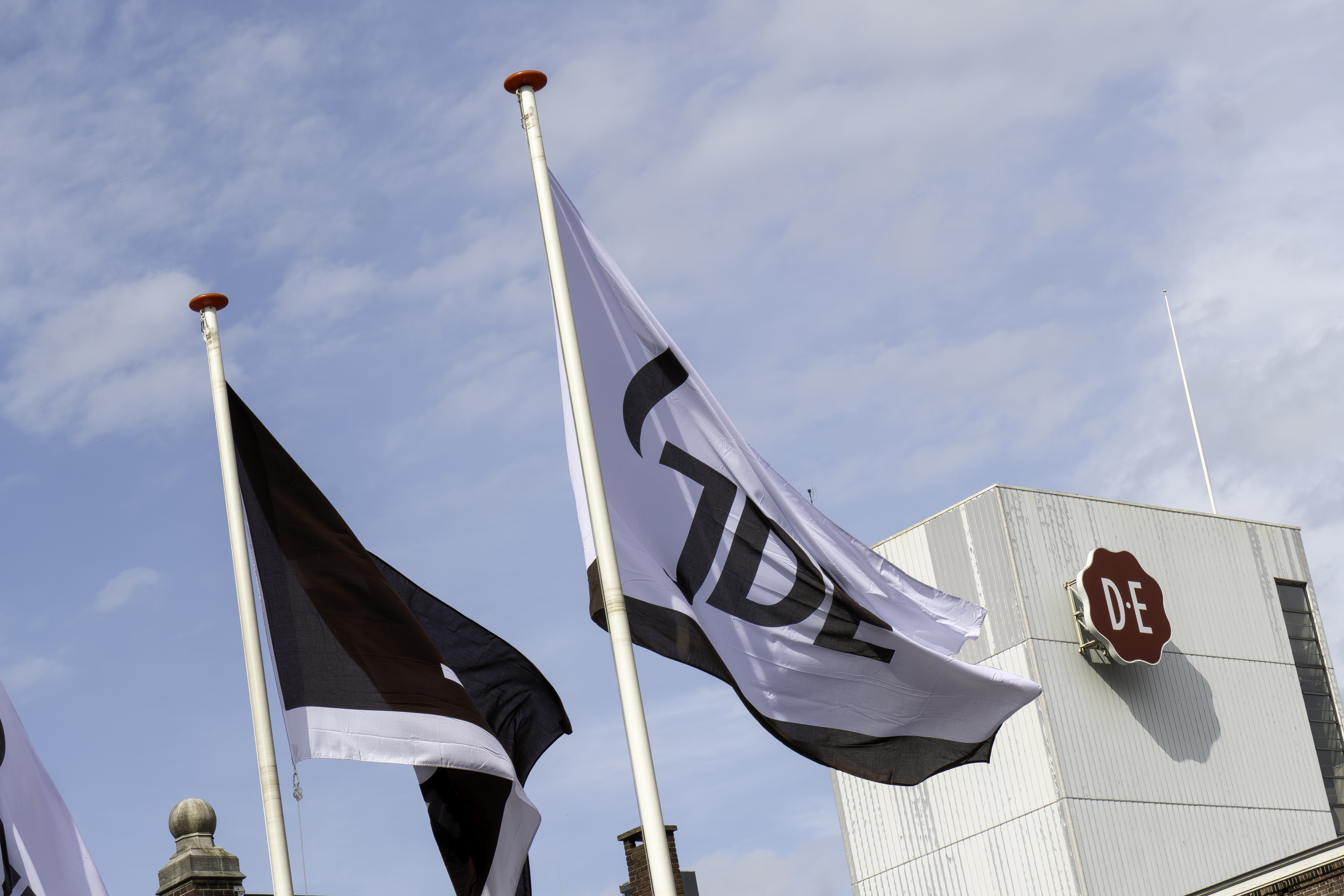 Logo en vlaggen van Douwe Egberts op de kofiiebranderij in Utrecht. Foto: ANP