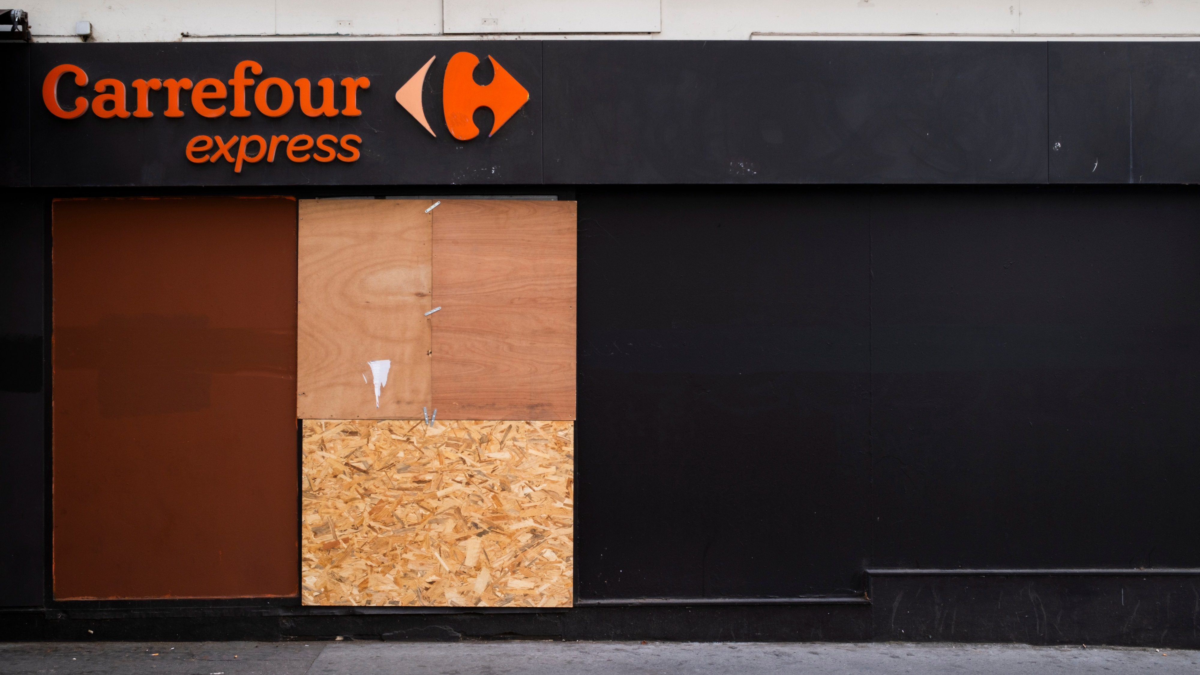 Een Carrefour in Parijs heeft houten planken voor de ramen uit angst voor rellen. Foto: ANP